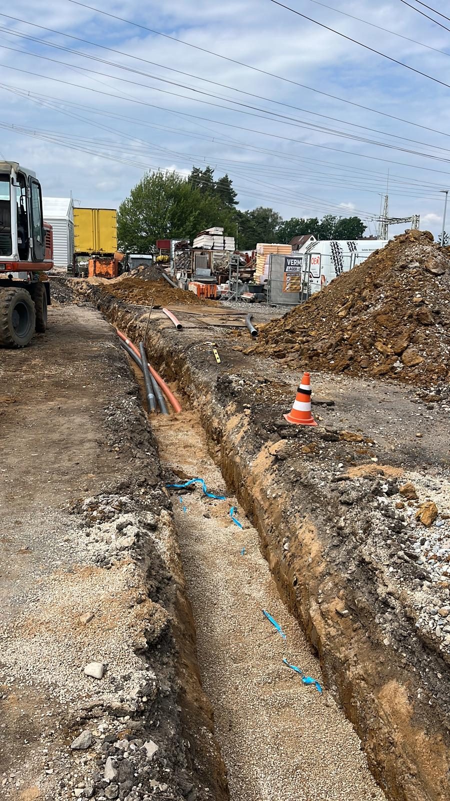 Leitungsgraben mit Warnband an einer Straßenbaustelle